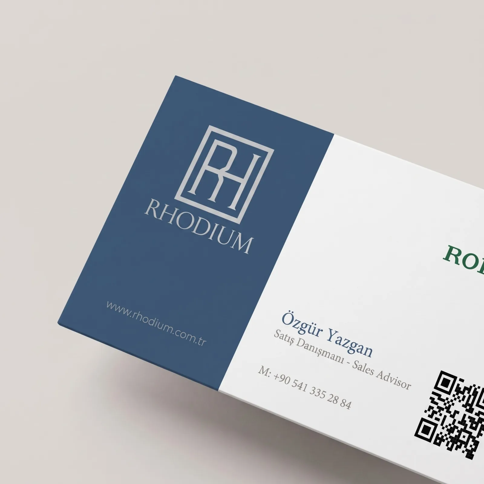 Rhodium kurumsal kimliğinden kartvizit: lacivert alanda RH monogram logosu, beyaz alanda iletişim bilgileri